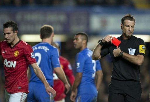 Referee Mark Clattenburg (R) puts his red card away after sending off Chelsea's Branislav Ivanovic (2nd L)